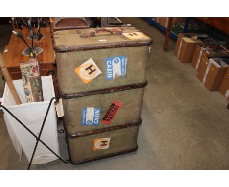 A wooden bound canvas travelling trunk bearing labels