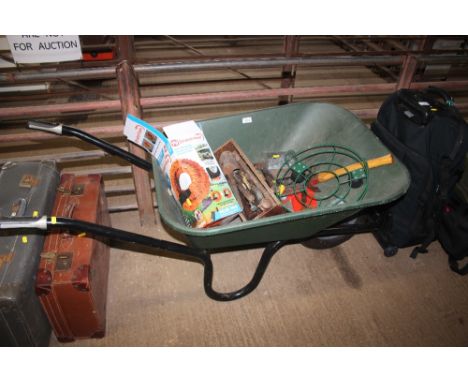 A plastic wheelbarrow and contents of various gardening tools etc