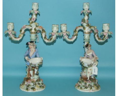 A pair of Continental porcelain candelabra, applied figures, flowers and foliage, 46 cm high (2) 