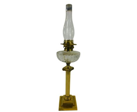 A late 19th/early 20thC Youngs brass oil lamp, with a fluted clear glass central reservoir, raised on a brass ionic column, o