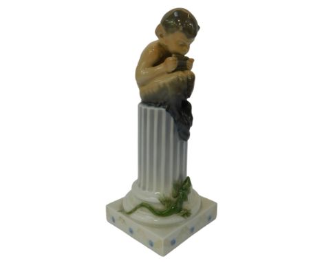 A Royal Copenhagen porcelain figure, modelled as Pan playing pipes, seated on a column beside a lizard, numbered 4133, bearin