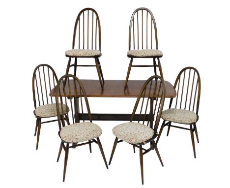 An Ercol dark elm trestle table, 70cm high, the top 74cm x 147cm, together with six loop back dining chairs, each with a soli