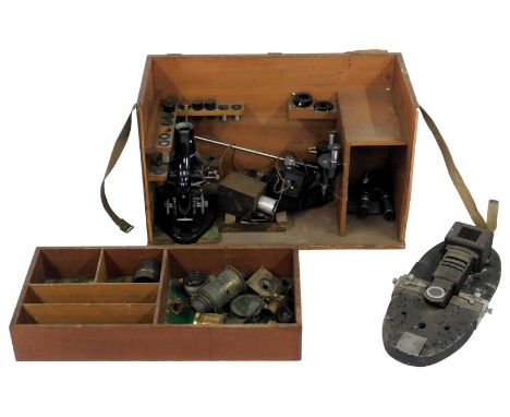 A fitted hardwood box containing a microscope by C Baker of London, model number 0877, with various attachments, lenses, etc,