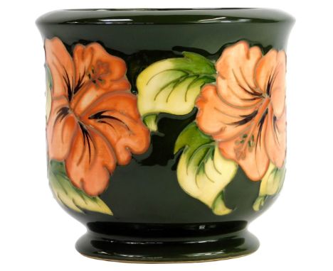 A Moorcroft pottery planter decorated in the Hibiscus pattern, dark green ground, impressed marks and initialled, 12cm high.