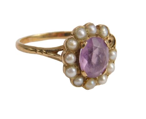 An amethyst and seed pearl cluster ring, the oval amethyst claw set surrounded by eleven seed pearls, one missing, yellow met