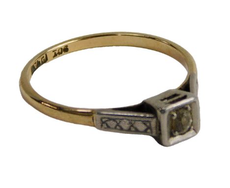 A diamond ring, in claw setting, in a square surround with engraved square decoration to the shoulders, yellow metal, marked 