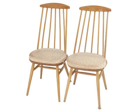 A pair of Ercol style elm and beech dining chairs, each with a tapering spindle back, solid seat, on cylindrical tapering leg