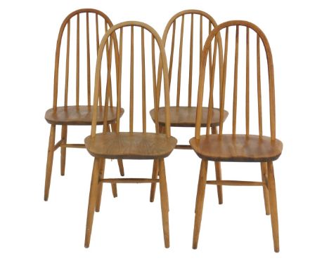 A set of four Ercol style light elm and beech dining chairs, each with a looped spindle back, solid seat, on cylindrical tape