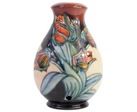 A Moorcroft pottery lamp base decorated in the Red Tulip pattern, of baluster form, impressed marks, 20cm high.