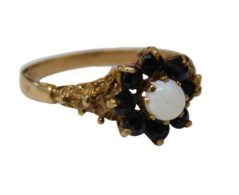 A 9ct gold sapphire and opal floral cluster ring, the central opal surrounded by eight sapphires, with splayed double flower 