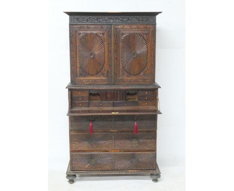 Anglo-Indian hardwood secretaire cabinet, circa 1900, carved throughout and with a fruiting vine frieze over two radial reede