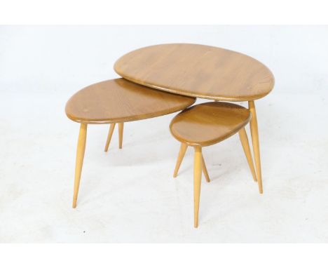 Ercol elm and beech nest of three 'pebble' occasional tables, the largest 65cm x 44cm 