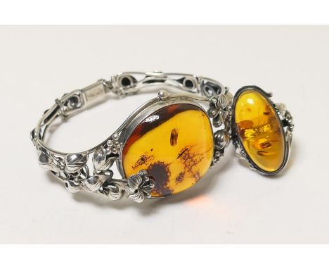 Baltic amber and silver bangle, having a large cognac coloured amber pebble, approx. 30mm diameter, set within an Art Nouveau