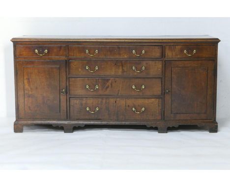 George III oak enclosed dresser, circa 1780-1810, having four central long graduating drawers flanked by two short drawers an