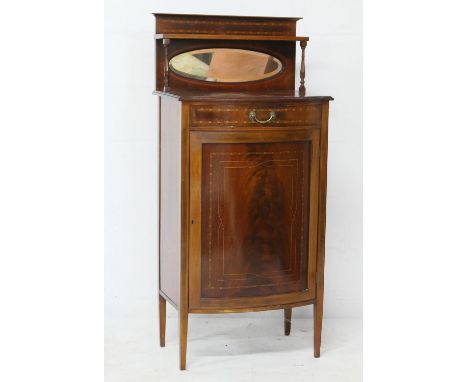 Edwardian mahogany and inlaid bow front music cabinet, circa 1900, the back with an oval mirror and a single shelf over a bow