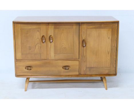 Ercol light elm small sideboard, fitted with three cupboard doors, one enclosing a cutlery tray, and a single drawer, all rai