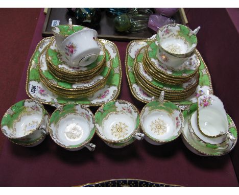 A Coalport Porcelain Part Tea Service, in the green "Batwing" pattern, decorated with sprays of flowers within gilt scrollwor