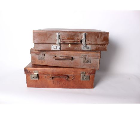 Three vintage leather suitcases.