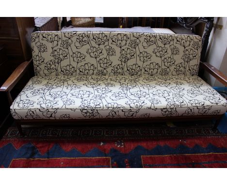 Two teak day beds - one with cream cushions and one with black floral print on cream cushions.   
