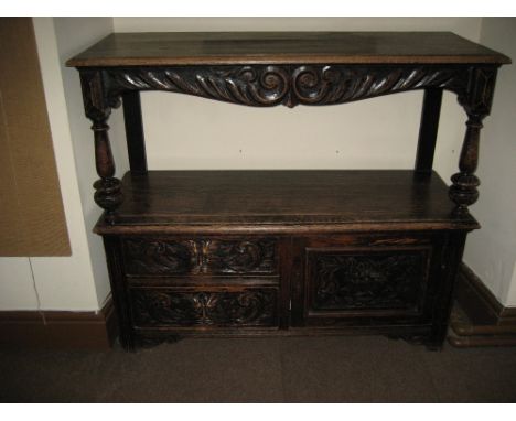 LATE 19TH CENTURY CARVED OAK BUFFET SIDEBOARD, the upper shelf having a carved and scrolled apron with turned front pillars t