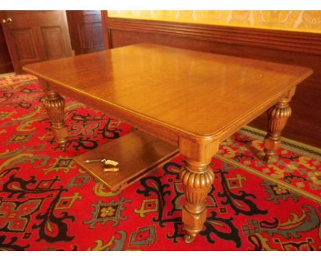 VICTORIAN OAK WIND-OUT DINING TABLE with rounded corner top and two additional slot-in leaves on substantial carved urn shape