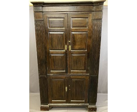 ANTIQUE OAK ONE PIECE STANDING CORNER CUPBOARD, twin upper and lower doors with chamfered panels, flanked by architectural ty