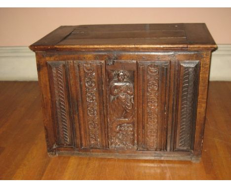 LATE 18TH CENTURY OAK COFFER having an inset lid to the top and with four narrow carved panels and a centre panel of a standi