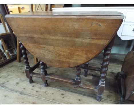 An oval oak gate leg dining table on barley twist legs 3' wide 