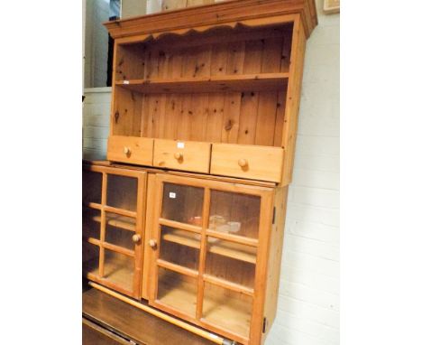 A pine wall hanging kitchen shelf unit with glass doors and a similar unit with spice drawers 