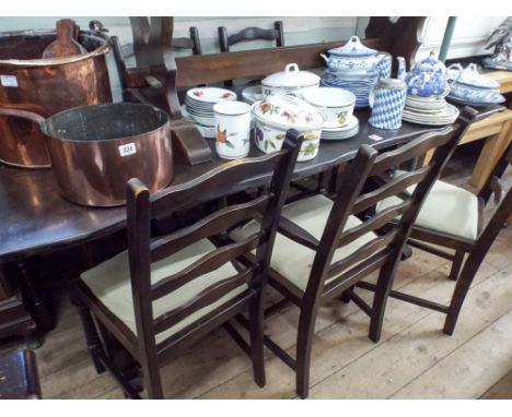 A dark oak refectory style dining table and six ladder back chairs with pale green upholstered seats, comprising of four stan