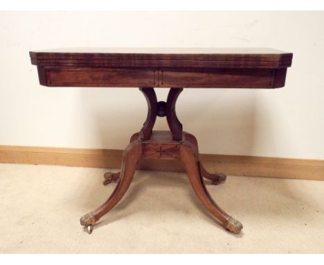 A regency ebony decorated mahogany folding top card table on quadruple base with brass feet 3' wide 