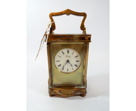 A gilt brass carriage clock circular white enamel dial signed Henley in shaped case, working, height including handle 18cms 
