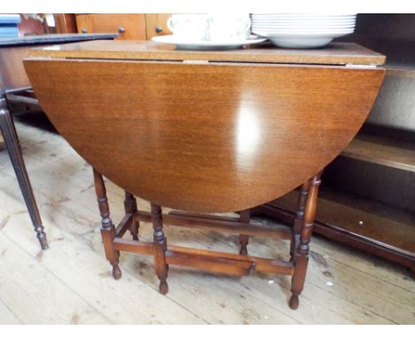 An oval oak gate legged table on turned legs, 2'6 wide 