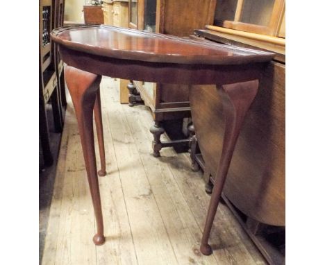 A reproduction semi-circular mahogany console table on cabriole legs 