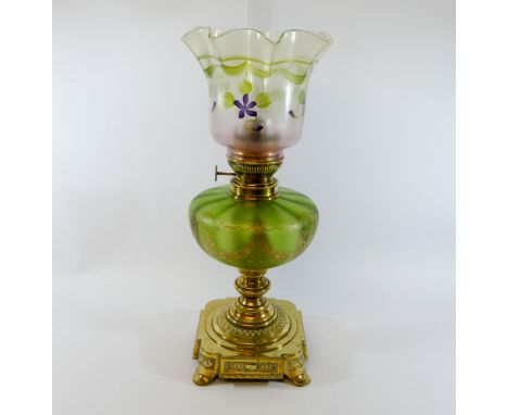 A Victorian brass and green glass oil lamp, with decorative reservoir, funnel and shade.  In very good condition