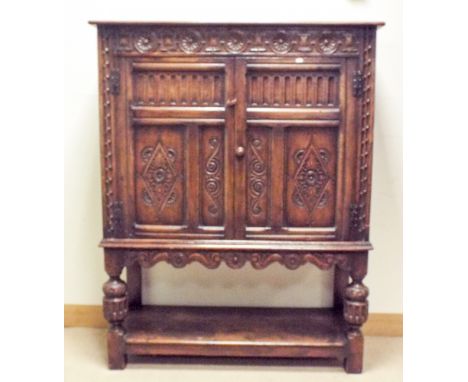 A 17th century style reproduction oak two door cupboard on carved bulbous legs with under shelf 47" wide 