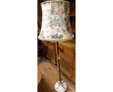 A brass and onyx standard lamp with paw feet and floral shade 