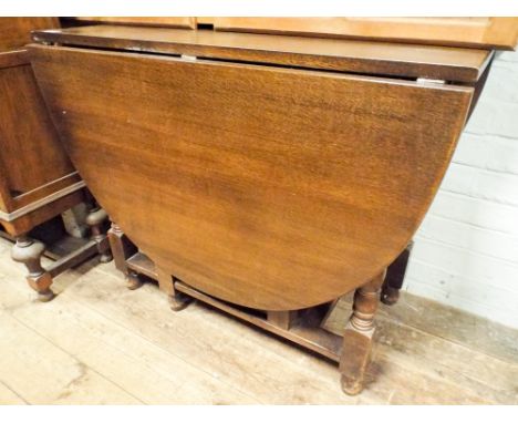 An oval oak gate leg dining table on turned legs 3' wide 