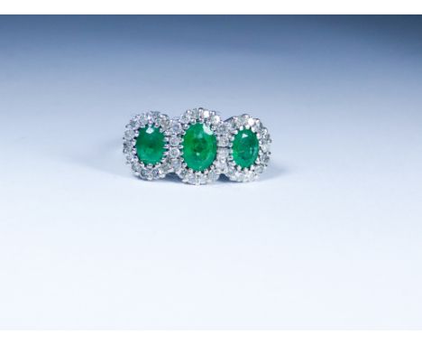 An 18ct white gold triple emerald and diamond cluster ring, ring size 'R'