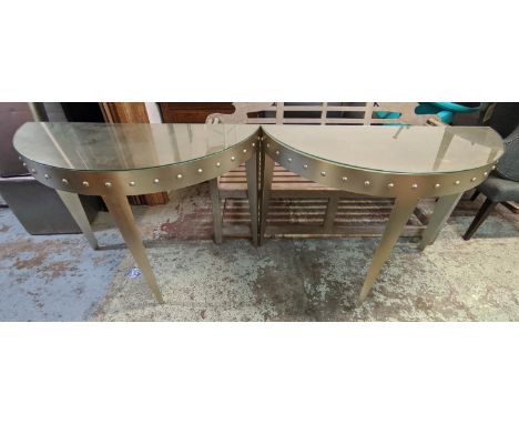DEMI-LUNE CONSOLE TABLES, a pair, 110cm W x 85cm H x 45cm D in a silvered finish with a studded frieze. (2) 