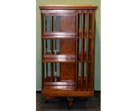 Large Edwardian oak three tier revolving bookcase, raised on a cross shaped support with ceramic castors, 114cm x 60cm.   CON