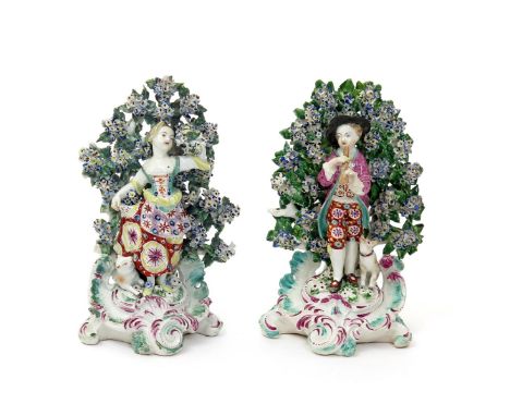 A pair of Derby figures of a young musician and his companion, c.1760-65, the young man playing the flageolet with his dog st