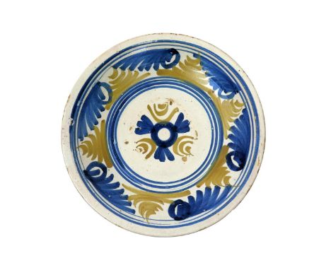 An early London or Brislington delftware charger, c.1660-80, the shallow form painted in a geometric design of stylized folia