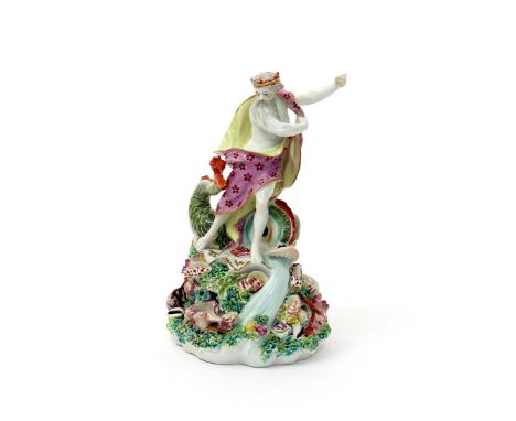 A Derby figure of Neptune, c.1760-65, standing on top of a tall base encrusted with shells, coral and seaweed, holding his bi