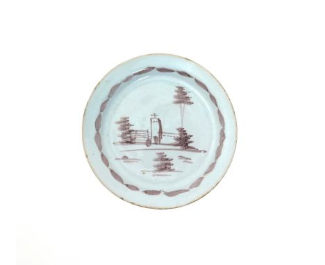 An early London delftware small plate or dish, c.1720, painted in manganese with a church beside a gate beneath tall trees, t