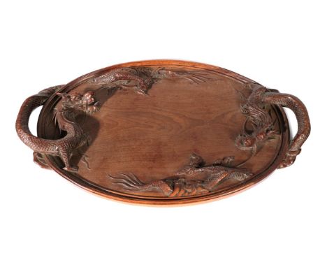 A Chinese Huanghuali Tray, Qing Dynasty, of oval form, the handles carved as dragons, 70.5cm wide.  One crack to the main pan