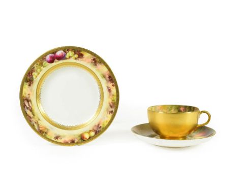 A Royal Worcester Porcelain Cup and Saucer, by William Ricketts, circa 1919, painted with still lives of fruit on a mossy ban