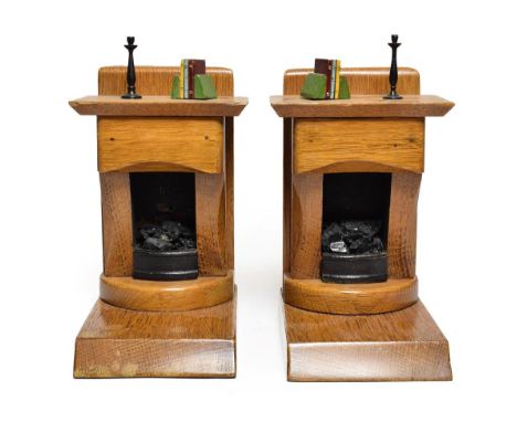 A Pair of Oak and Painted Wood Bookends, 20th century, each modelled as a fireplace, a candlestick and books on the mantelpie