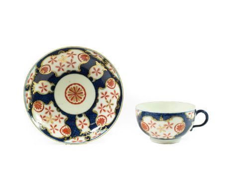 A Worcester Porcelain Teacup and Saucer, circa 1770, painted with the Queen's Japan Star pattern on a blue scale ground, seal