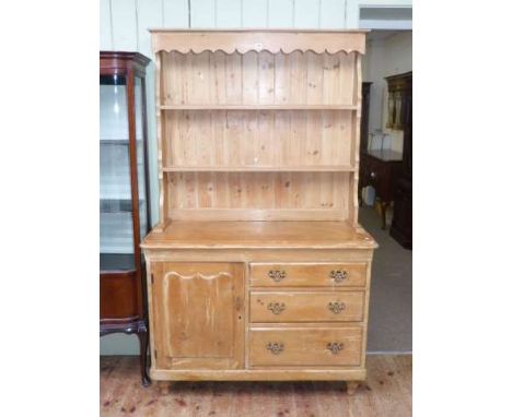 Pine dresser having shelf back above three drawers and cupboard door on turned legs